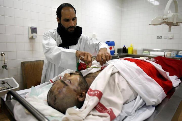 21 février 2011 : Abdulrheda Mohammed est l'un des participants à la manifestation de Pearl roundabout qui ont été tués par les forces gouvernementales. Il a succombé à de très violentes blessures portées à la tête et son corps a été transféré à la morgue du complexe médical Salmaniya. Sur ce cliché terrible publié par le Los Angeles Times, son frère Ahmed Buhmaid vient respectueusement poser une rose rouge sur le corps de son frère défunt.