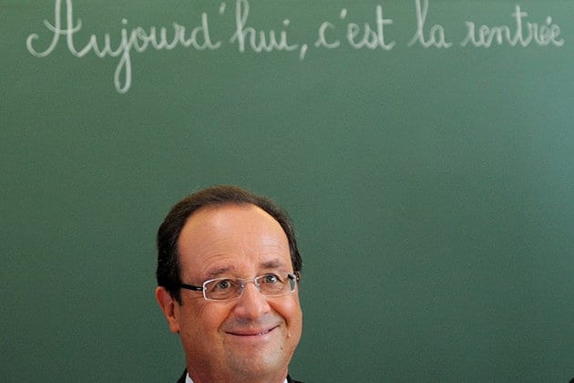 French President Francois Hollande smiles as he chairs a round table discussion on the changes in the school timetable set out by the government during a visit to the primary school Michelet on the first day of the new school year in Denain